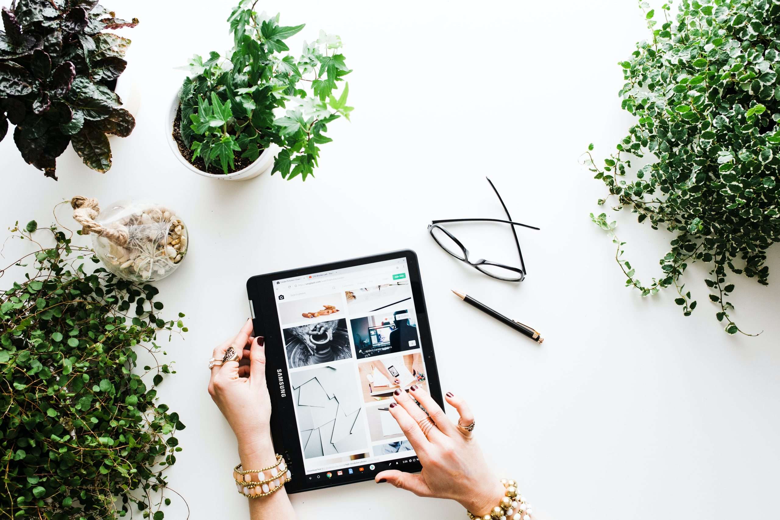 woman selling things on table against white background with plants
