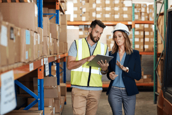 Two workers in a warehouse surrounded by stock